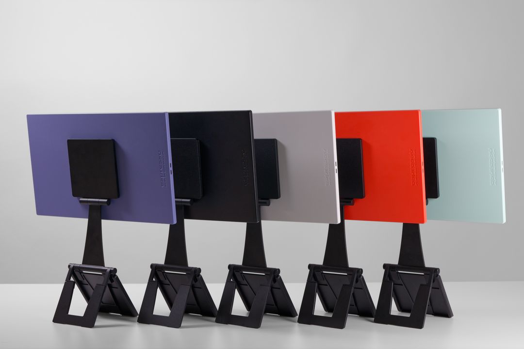 Five espresso Lite 15 monitors viewed from behind, showing purple, black, white, orange and mint finishes on Stand+ supports.