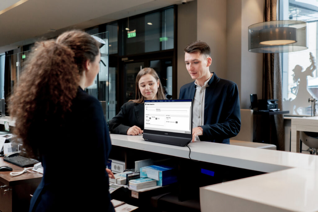 Philips dual-sided monitor on a reception counter with visitors facing its rear display