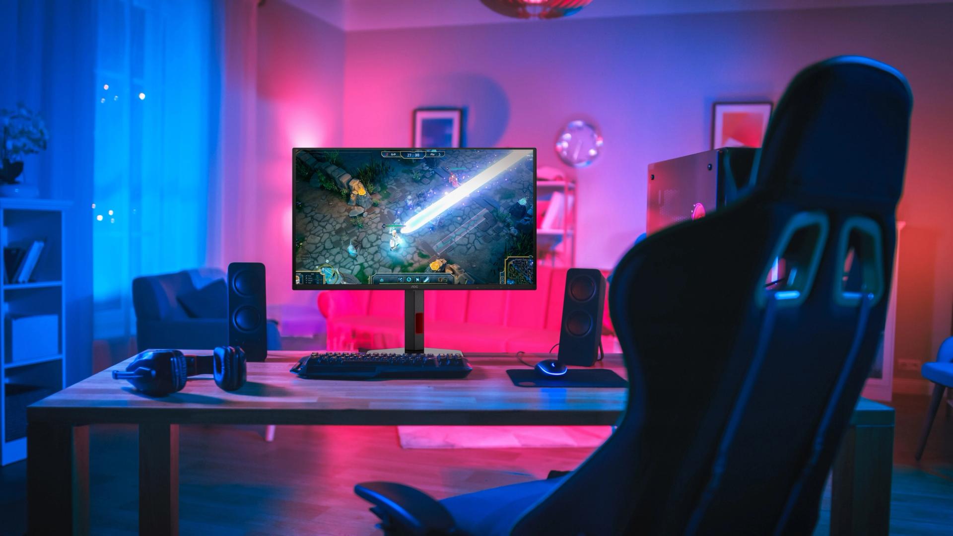 AOC Q27G4ZD on a gaming desk in the original blue-and-purple-lit room photograph.