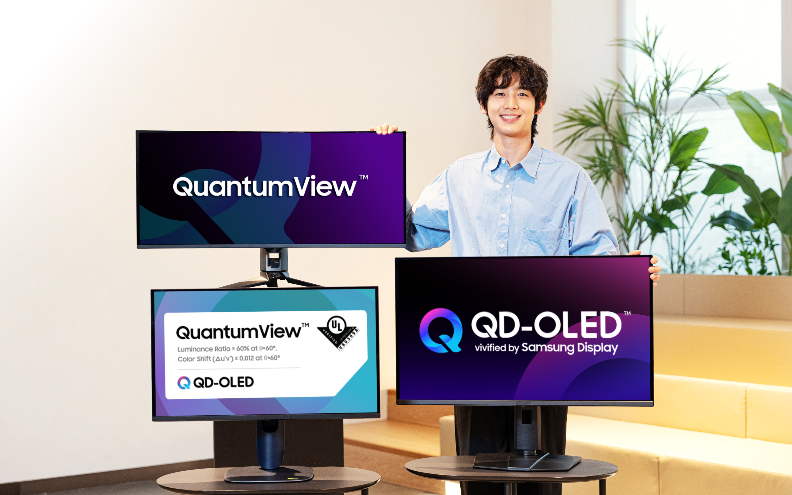 Three QD-OLED monitors display QuantumView branding and the UL verification criteria.