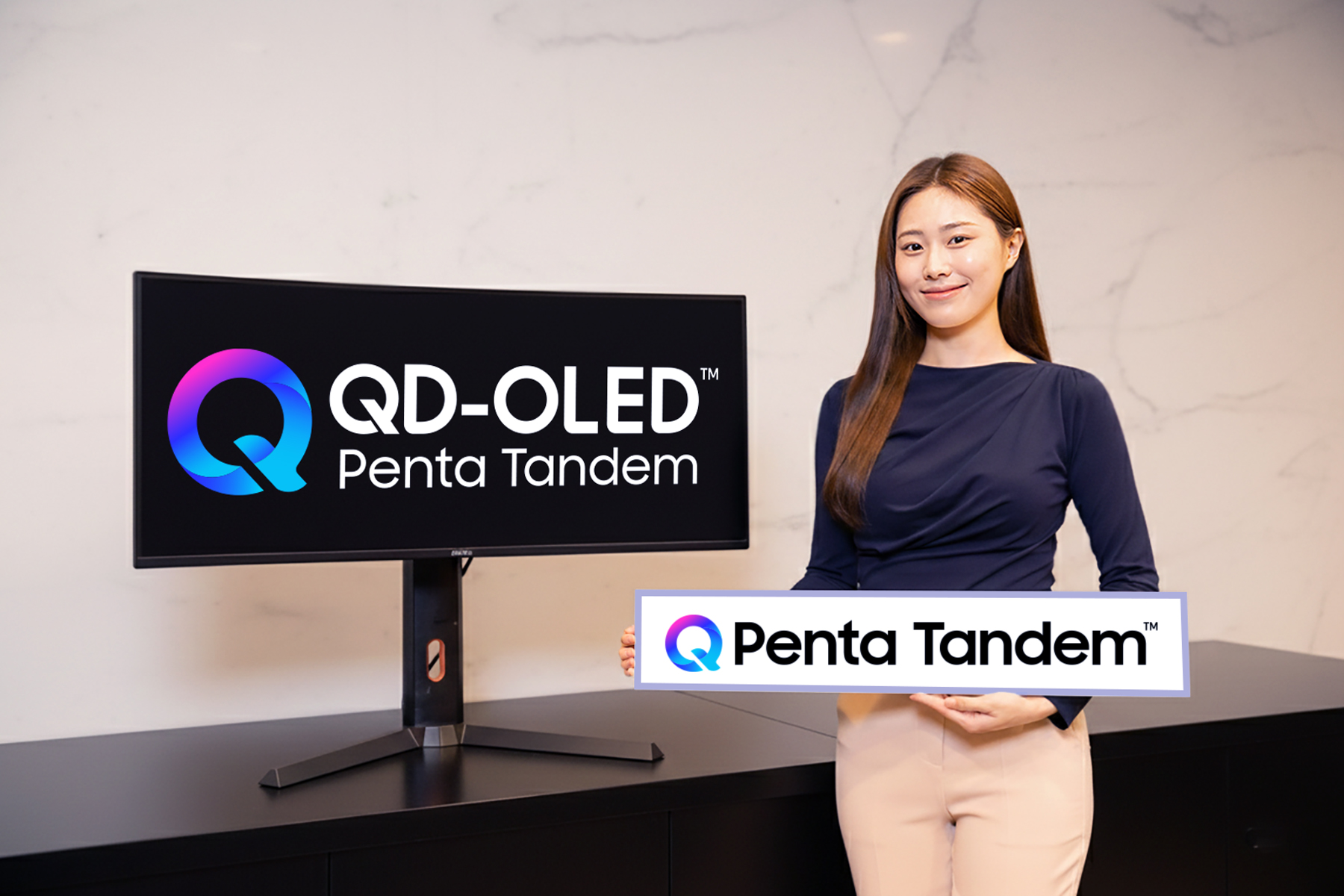 Samsung Display presents a monitor and sign carrying QD-OLED Penta Tandem branding.