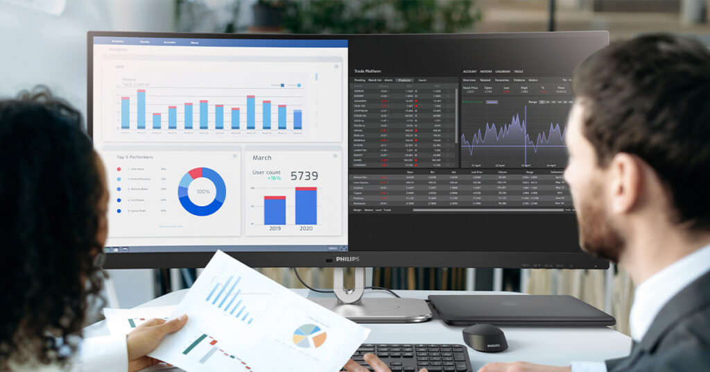 Philips business ultrawide showing dashboards to two people at an office desk